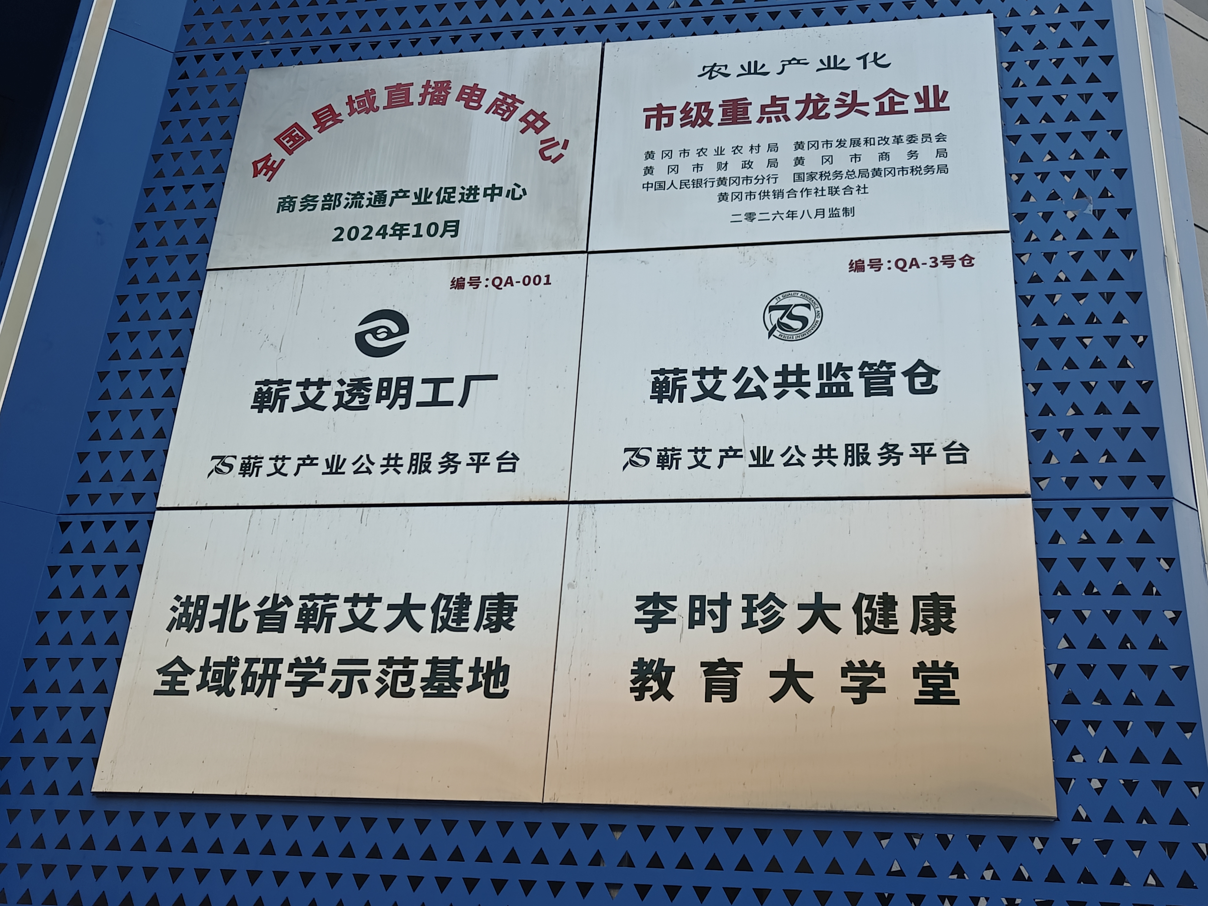 农业产业化市级重点龙头企业、全国县域直播电商中心、蕲艾透明工厂与公共监管仓等六块现场牌匾