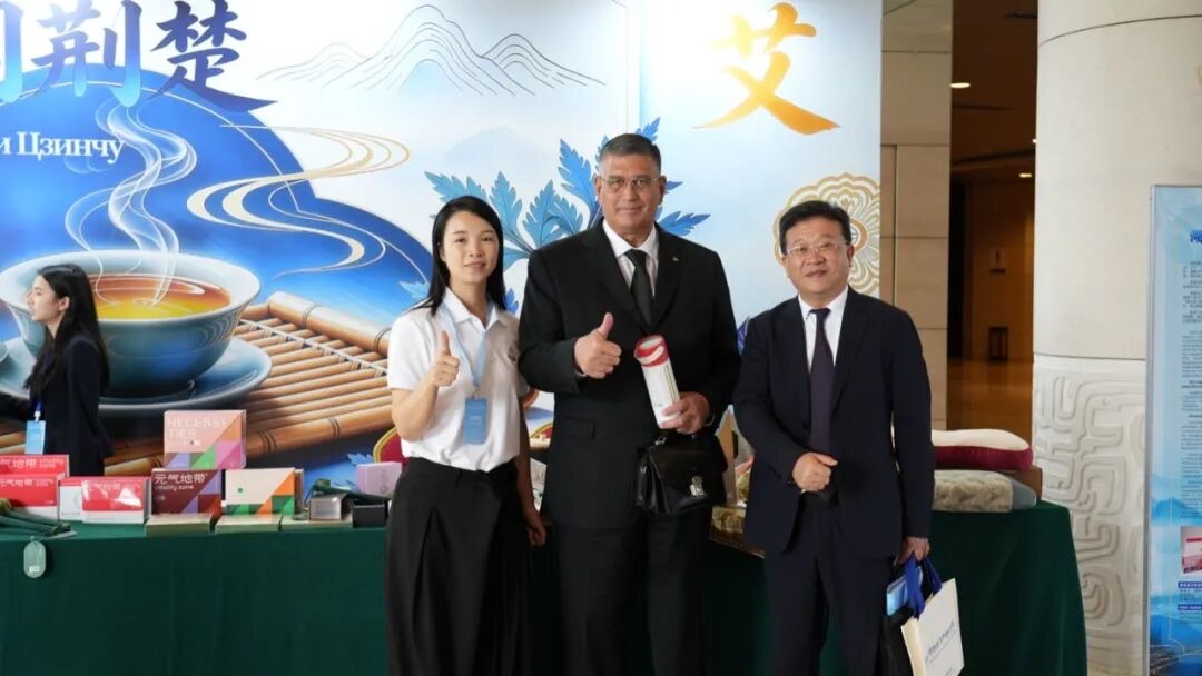 吴晓洁经理向外方代表演示明大妈艾枕，翻译在旁转述