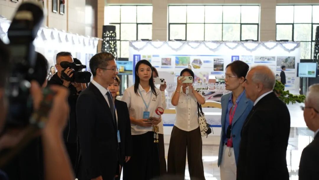 论坛期间，代表团在展区参观，随行媒体在旁拍摄