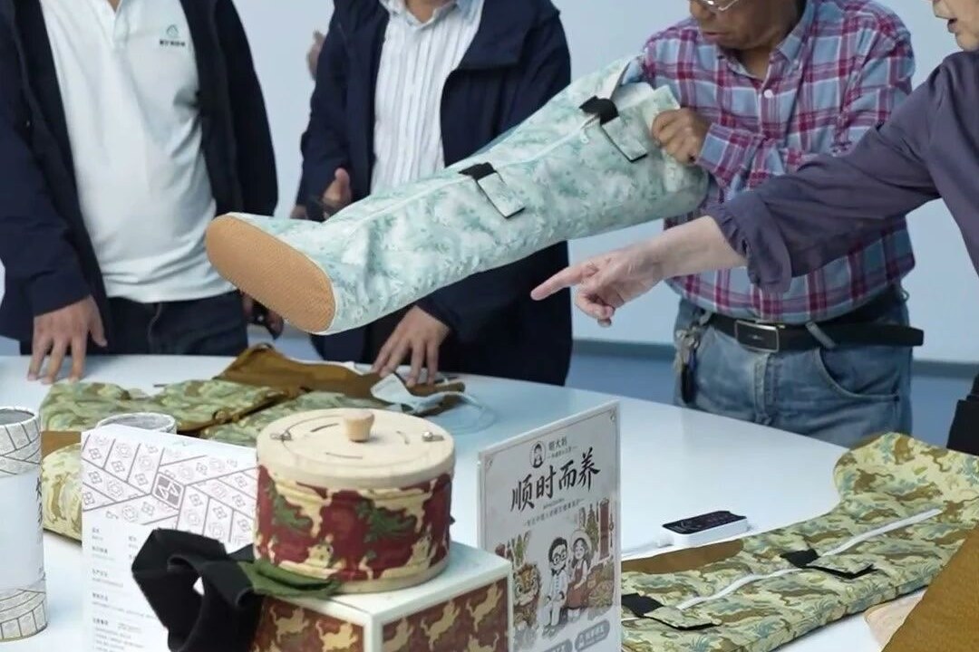 老同志们近距离查看布艺类蕲艾制品