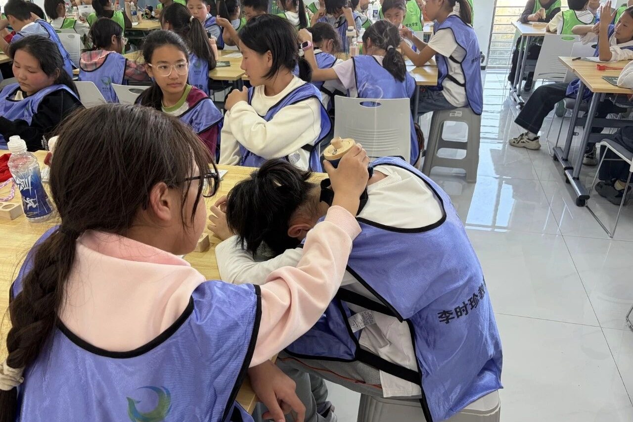同学们在工作人员指导下了解蕲艾器具